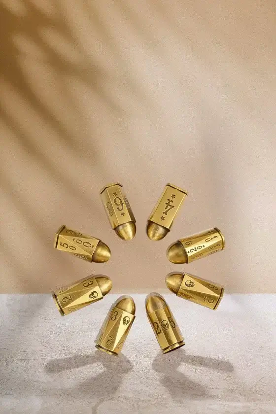 Golden bullet casings arranged in a circular pattern on a surface.